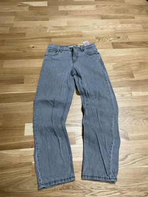 Grå Levi's loose taper jeans 14A - Säljer ett par grå jeans från Levi's i loose taper-modell. Byxorna har klassiska fem fickor, raka ben med avsmalnande passform och normal midja. Tillverkade i mjukt jeanstyg och har den ikoniska Levi's-lappen bak i midjan.