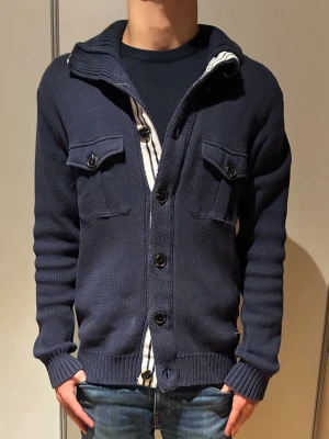 stickad cardigan  - Säljer en unik marinblå stickad cardigan. Perfekt för lager på lager och en avslappnad stil. Priset ej hugget i sten!