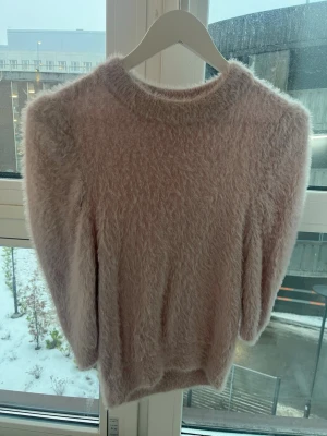 Ljusrosa fluffig tröja VRS Woman XS - Supermjuk och fluffig ljusrosa tröja från VRS Woman i storlek XS. Tröjan har lång ärm och rund halsringning, perfekt för dig som vill ha en cozy vibe. Materialet är lurvigt och känns riktigt mysigt mot huden.