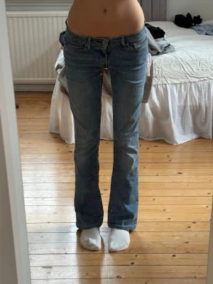 Levis bootcut lågmidjade jeans - Lågmidjade bootcut jeans från Levis i storlek 26, jag är 164cm och brukar ha xs💕 fint skick, fläck på baksidan(se bild) benen är uppsprättade för att bli längre men går enkelt att sy upp igen💕