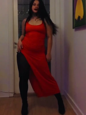 Röd långklänning med smala axelband - Säljer en snygg röd långklänning med smala axelband och djup rygg med knyt. Klänningen har en tight passform upptill och slits på sidan. Materialet är glansigt och stretchigt, vilket ger en riktigt cool look.