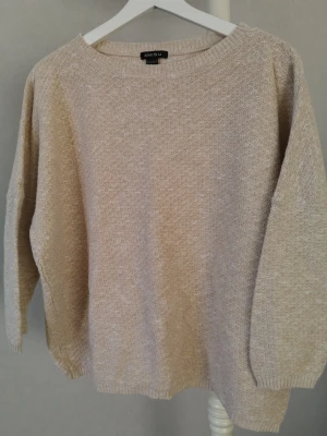 Beige stickad tröja från Amisu - Säljer en beige stickad tröja från Amisu i storlek L. Tröjan har en avslappnad passform, rund halsringning och trekvarts ärmar. Materialet är mjukt och strukturerat, perfekt för lager på lager under kyligare dagar.