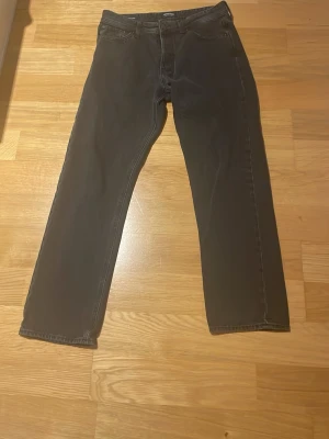 Svarta relaxed jeans från Jack & Jones - Svarta jeans från Jack & Jones i modellen Relaxed/Chris. De har en loose passform med raka ben och klassisk femficksdesign. Materialet är jeans och färgen är mörk svart. Perfekt för dig som gillar avslappnad stil och vill ha bekväma jeans.