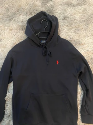 Mörkblå hoodie från Polo Ralph Lauren - Snygg mörkblå hoodie från Polo Ralph Lauren,Väldigt skön och passar bra,den är i storlek S och är i nyskick.