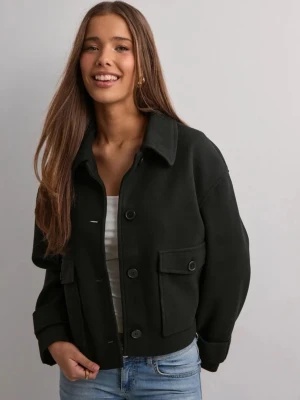 Svart kappa - Säljer en svart kappa med stora fickor framtill och knappar längs hela framsidan. Jackan har en klassisk krage, breda ärmslut. strl m men skulle säga strl s