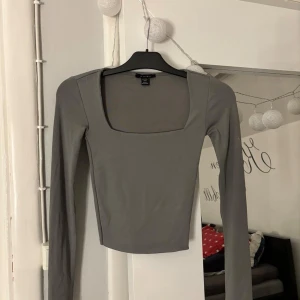 Grå långärmad topp från Amisu - Hej, säljer en grå långärmad topp från Amisu i storlek XXS. Toppen har en fyrkantig urringning vilket ger en snygg struktur. Passformen är slim och toppen är något croppad. Använd sparsamt, hör av er vid frågor!💕