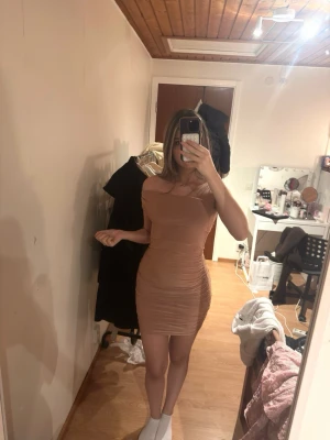 Ljusrosa offshoulder kortklänning - Säljer en snygg ljusrosa kortklänning med offshoulder-design och rynkade detaljer längs sidorna. Har använt den en gång!