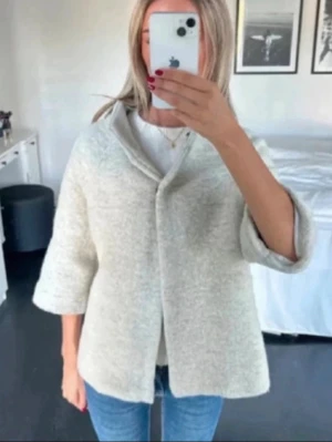 Svart ullkappa med trekvartsärm - Så fin trekvartsärmad kappa i 70% ull! Gjord i Italien. Verkligen så fin och passar till många tillfällen. OBS !!! Den första bilden är lånad men är i samma modell som den svarta jag säljer. Kappan som säljs är alltså den svarta på bild 2 och 3💕Uppskattad storlek är S. Superbra skick🌟