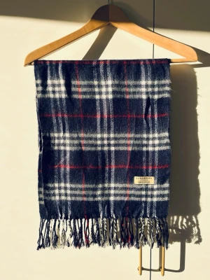 Burberry halsduk - Äkta Burberry halsduk i ikonisk check. En garderobsklassiker som aldrig blir omodern. | Mått: ca 168 × 30 cm | | Material: 100 % kashmir | | Mycket bra skick. |