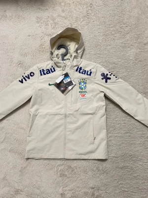 Nike brasil jacka beige  - Helt ny Nike brasil jacka i färgen beige. Storlek M väldigt fin i färgen. Skriv vid intresse!