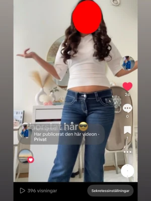 Mörkblå jeans med vita sömmar - Säljer ett par mörkblå jeans med tydliga vita kontrastsömmar och klassiska bakfickor med lock. Jeansen har låg midja och raka ben, tillverkade i jeansmaterial. Perfekta för dig som gillar en avslappnad och tidlös stil.