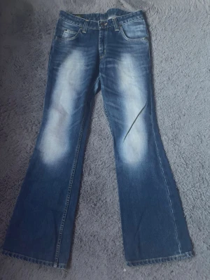 Blå bootcut jeans från Lee, 28/31 - Säljer ett par blå bootcut jeans från Lee i modellen Desoto. Femficksmodell med normal passform och tydliga Lee-detaljer på bakfickan. Dom är midwaist💗