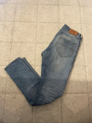 Blå jeans Pistolero 30/34 - Säljer ett par klassiska blå jeans från Pistolero i modellen Ultima. Jeansen har raka ben, fem fickor och snygga kontrastsömmar. Tillverkade i slitstarkt denim och passar dig som gillar en tidlös look. Perfekt för dig som vill ha ett par jeans med normal passform.
