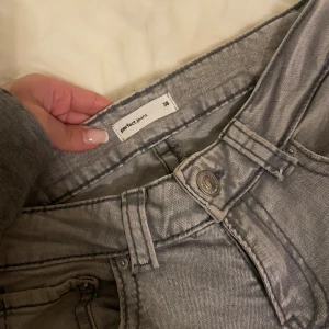 Grå bootcut jeans  - Grå bootcut jeans från Perfect Jeans i klassisk y2k-stil. Jeansen har låg midja, fem fickor och coola sömdetaljer. Tillverkade i mjukt denim-material som sitter skönt och ger en avslappnad vibe. 