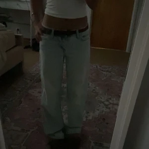 Ljusblåa baggy jeans med låg midja - Säljer ett par ljusblåa jeans med baggy passform och låg midja. Jeansen har klassiska fickor, breda ben och snyggt slitna detaljer. Perfekta för en avslappnad och trendig look.