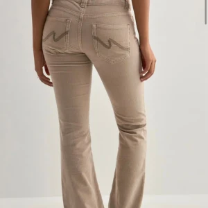 Beiga bootcut manchesterbyxor - Snygga lågmidjade beiga byxor med bootcut passform, från Nelly. Original pris: 699kr. 