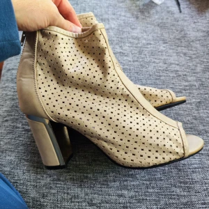 Beige stövletter med öppen tå, Belle&Beauty - Snygga beige stövletter från Belle&Beauty med perforerat mönster och öppen tå. Skorna har bred klack och är tillverkade i skinnliknande material. Perfekta för dig som vill ha en trendig och luftig sko med coola detaljer.