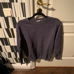Mörkblå sweatshirt med rund hals - En enkel och stilren mörkblå sweatshirt med rund halsringning och långa ärmar. Tröjan har ribbade muddar vid ärmslut och nederkant, perfekt för en avslappnad och snygg look.