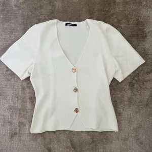 Vit topp med gulddetaljer - Jättefin topp från Gina. Endast använd fåtal gånger. Inga anmärkningar 