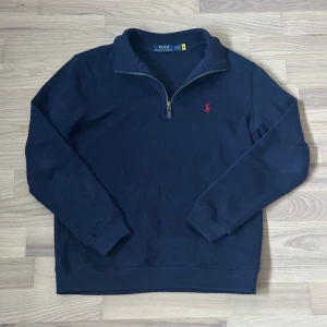 Ralph Lauren polo shirt - Helt ny snygg marinblå långärmad tröja från Polo Ralph Lauren med half zip och klassisk röd broderad logga på bröstet. Tröjan har en hög krage och är gjord i mjuk bomull, perfekt för chill dagar. Stilren och enkel design som funkar till jeans eller chinos. Pris kan diskuteras.
