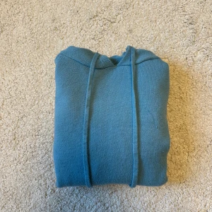 Ljusblå stickad hoodie - Säljer en ljusblå stickad hoodie med merinoull liknande material. Tröjan är använd bara ett fåtal gånger och är iprincip nyskick bara lite noppig men går nog att lösa. Den passar dig som är omkring 160-170cm lång. Skriv vid intresse! ”Obs 179kr är absolut lägsta pris”