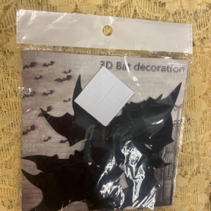 3D Bat decoration / Halloween Decoration  - Paket med 3D-fladdermusdekorationer för vägg, perfekt för Halloween eller temafester. Innehåller flera svarta plastfladdermöss och självhäftande kuddar för enkel montering. Produkten är ny och oöppnad i originalförpackning.