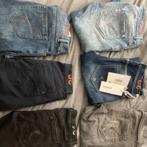 Flera par Dondup jeans i olika färger - Säljer sex par Dondup jeans i olika tvättar och färger: ljusblå, mellanblå, mörkblå, svart, grå och mörkgrå. Klassisk femficksmodell med tydliga sömmar och Dondup-logga på bakfickan. Perfekta för dig som gillar snygga och stilrena jeans. Köp flera par för bättre pris, styck pris annars beroende på vilka du vill köpa. Uppmärksamma att jeansen är olika mycket använda och kan vara mer eller mindre slitna. Alla är strlk 30 George. Pris för 6 par: 4000