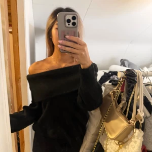 Svart offshoulder stickad tröja - Säljer en svart stickad tröja med bred offshoulder-ringning. Tröjan har lång ärm och en oversized, avslappnad passform. Perfekt för dig som gillar en trendig och chill stil. Supermjuk och skön att bära under kyligare dagar. Står ingen storlek men passa mig som bruka ha xs-S