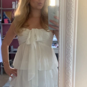 Vit kort volang klänning - Supersöt vit kort klänning från Nelly. Använd 1-2 gånger och är därmed i väldigt bra skick. Super snygg med en stickad tröja på nu i höst eller bara själv som den är💗Storlek S är slutsåld därav priset, men det kan diskuteras!