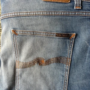 Nudie Jeans Lean Dean 36W-28L - Snyggt slitna ljusblå jeans med mindre lagning i grenen och sömmar på vänster ben. Sitter som storlek 38W - 30L. Extremt bekväma. Har mycket kvar att ge. Lagade mellan skrev