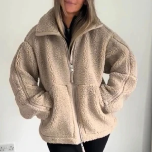 Beige teddyjacka med dragkedja - Mysig och oversized teddyjacka i beige med hög krage och praktisk dragkedja framtill. Jackan har två stora fickor och är tillverkad i fluffigt fleece-material som håller dig varm och skön under kyliga dagar. Perfekt för dig som gillar avslappnad stil. Priset går att diskutera 🩷🩷🩷