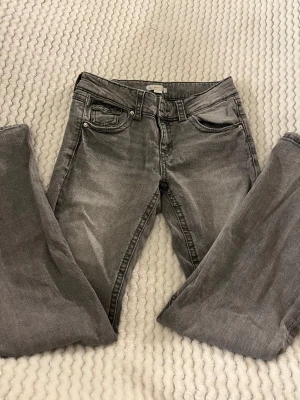 Grå jeans från Gina Tricot - Gråa jeans från Gina Tricot i storlek 164. Finns små slitningar längst ner på byxbenen men ingenting man lägger märke till.