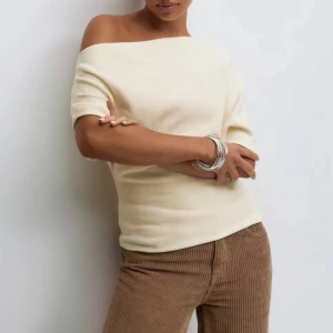 Offshoulder stickad topp i beige - Säljer min Superfin helt oanvända offshoulder topp i ljusbeige stickat material. Tröjan är helt slutsåld från ginatrigot i båda beige och grå. 