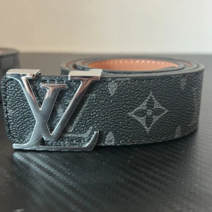 V-L (baklänges) bälte monogram - svart VL bälte med svart monogram och silver logga 