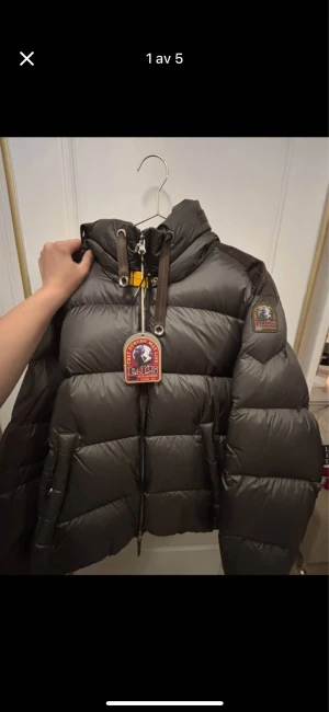  Parajumpers dunjacka Tilly - Säljer en fet mörkgrön Parajumpers Tilly dunjacka med huva och coola patchar på ärmen. Jackan har snörning vid kragen, dragkedja framtill och två stora fickor. Färgen är olivgrön. Aldrig använd med lapp på. Nypris 7349kr. 