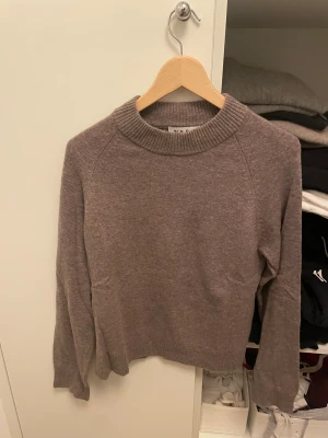 Beige stickad tröja från Wera - Mysig beige stickad tröja från Wera med rundad, ribbad hals och långa ärmar. Tröjan har en enkel och clean look, perfekt för dig som gillar basic och neutrala färger. Passformen är normal och materialet känns mjukt mot huden. Nypris 800kr knappt använd