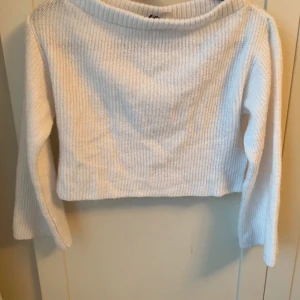 Vit croppad stickad tröja H&M Divided - Säljer en vit croppad stickad tröja från H&M Divided i storlek XS. Tröjan har ribbad struktur, lång ärm och en bred, rundad halsringning. Perfekt för dig som gillar en enkel och clean look med lite edge.