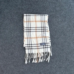 Burberry scarf - Burberry-scarf som är 100% äkta. Mindre defekter kan förekomma enligt bild men inget märkvärdigt då de är vintage. Snabb leverans och trygg handel då vi har 7 års erfarenhet i branschen. Vid frågor eller bud, skicka gärna ett meddelande. 1018