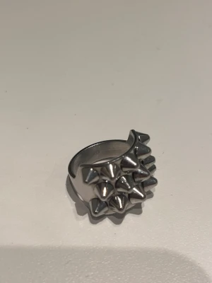 Silvrig ring med nitar från EDBLAD - Edblad ring i storlek 16,5 i mycket bra skick, säljer eftersom den aldrig kommer till användning. 