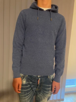 Merinoull hoodie - Jättefin merinoull hoodie i blå från Melker Ahlquist egna märke. Knappt använd, säljer pga av att den blivit för liten. Den är även helt slut online 
