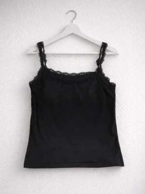 Svart kort linne med spetsdetalj, strlk S - Ett svart kort, enkelt, basic linne med spetsdetalj. Köpt secondhand och har aldrig kommit till användning! Ingen storlekslapp finns kvar, men passar uppskattningsvis en storlek S. Perfekt för både vardag, fest och om man vill till sovlinne. FÖRST TILL KVARN!