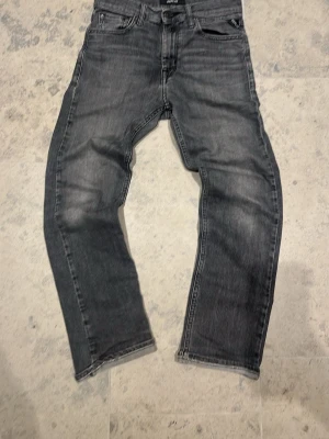 Svarta replay jeans - Snygga svarta replay jeans med lätt tvättad look och klassisk femficksdesign. Jeansen har en slim passform och raka ben, perfekta för en stilren vardagsoutfit. Tillverkade i mjukt och slitstarkt bomullsjeansmaterial.