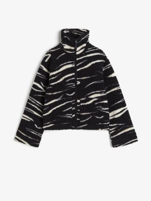 Zebramönstrad teddyjacka - Säljer en svart teddyjacka med zebramönster i vitt. Jackan har hög krage, dragkedja framtill och är gjord i mjukt, fluffigt material som ger en cozy vibe. 