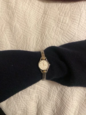 Klassisk liten silverfärgad armbandsklocka - Stilren armbandsklocka med rund vit urtavla och silverfärgat metallarmband. Vintage.  tidlös design.💕💕💕