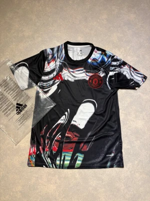 Manchester United x Adidas träningströja - Man united tröja med old trafford bakgrund som är en special edition tröja som är väldigt snygg, hör av er vid fler frågor🤝