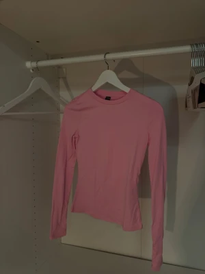 Rosa långärmad topp från SHEIN - En enkel och snygg rosa långärmad topp från SHEIN TALL. Modellen är figurnära med rund halsringning och tillverkad i ett mjukt material som känns skönt mot huden. Perfekt att matcha med jeans eller kjol för en clean look.💓