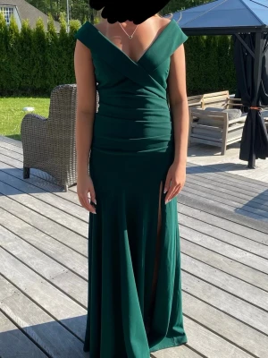 Mörkgrön balklänning - Jag säljer denna klänning som jag hade på balen i 9:an förra året. Den är använd en gång och är i jättebra skick🥰 Den är i storlek S och längden är uppsydd så att den är perfekt för mig som är 163cm lång😊Den är den perfekt balklänningen🥰🥰