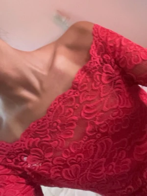 Röd spets topp offshoulder - Snygg röd offshoulder topp i spets med blommigt mönster. Toppen har korta ärmar och en figurnära passform. Skulle säga den är mellan röd och hot pink