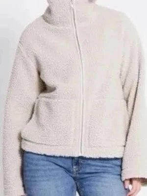 Beige teddyjacka med dragkedja - Mysig beige teddyjacka med hög krage och hel dragkedja framtill. Jackan har en loose passform och är tillverkad i mjukt teddy-material som ger en avslappnad och trendig look. Perfekt för kyliga dagar och enkel att matcha med jeans eller leggings.