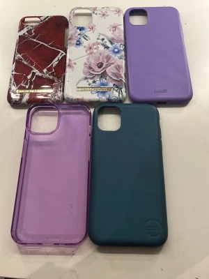 iphone skal. 50kr st. - Säljer fem olika iPhone skal: ett rött med marmormönster iphone 6, ett blommigt i vitt och rosa iphone 11, ett lila iphone 11, ett genomskinligt lila iphone 13 och ett mörkgrönt i återvunnen plast iphone 11. Skalen är i plast och silikon och passar iPhone-modeller med stor kameraöppning.